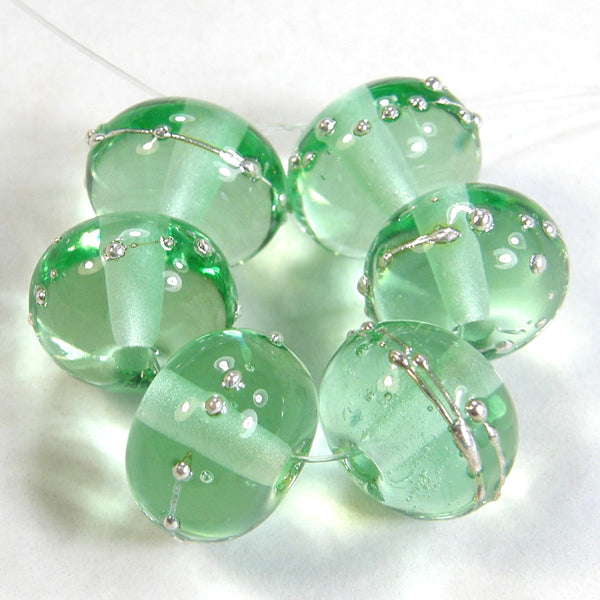 Example of shiny pale green lampwork beads wrapped in fine silver to show color of bead.